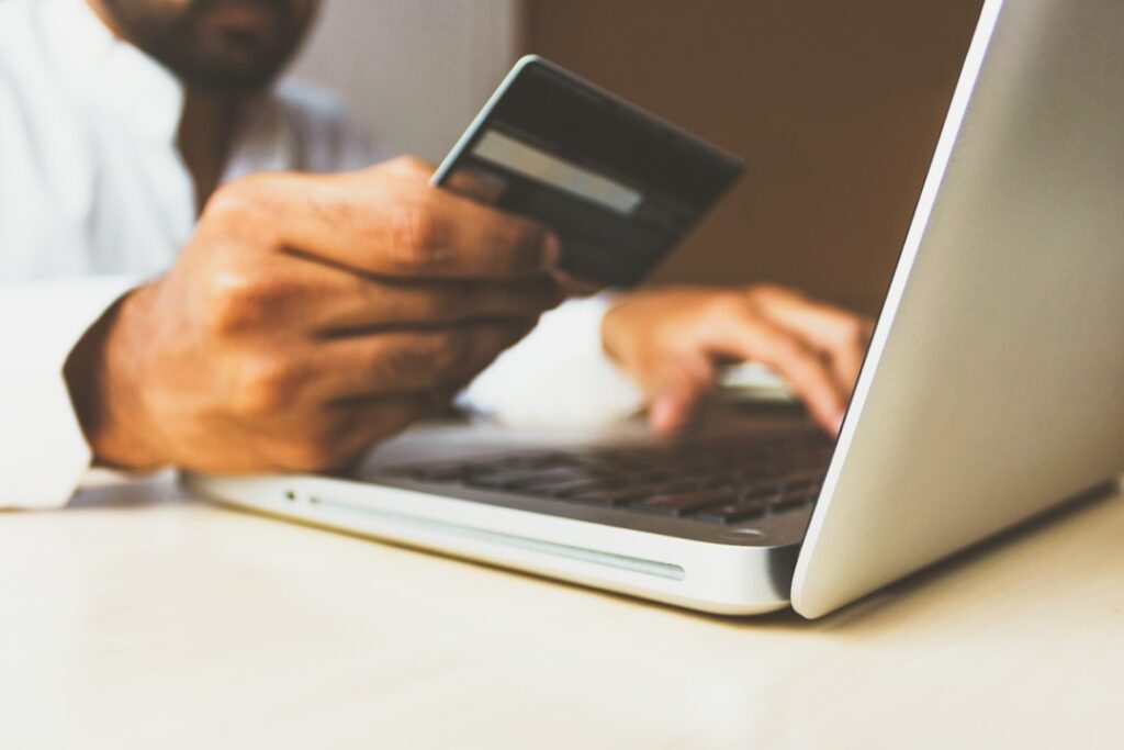 Person on laptop holding credit card to show how intelligent search can transform online shopping and e commerce businesses